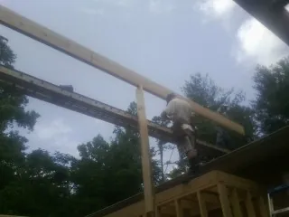 Carpenter setting a ridge beam over a new addition frame — Ice Dam Removal by Roofing Brothers in Sarver
